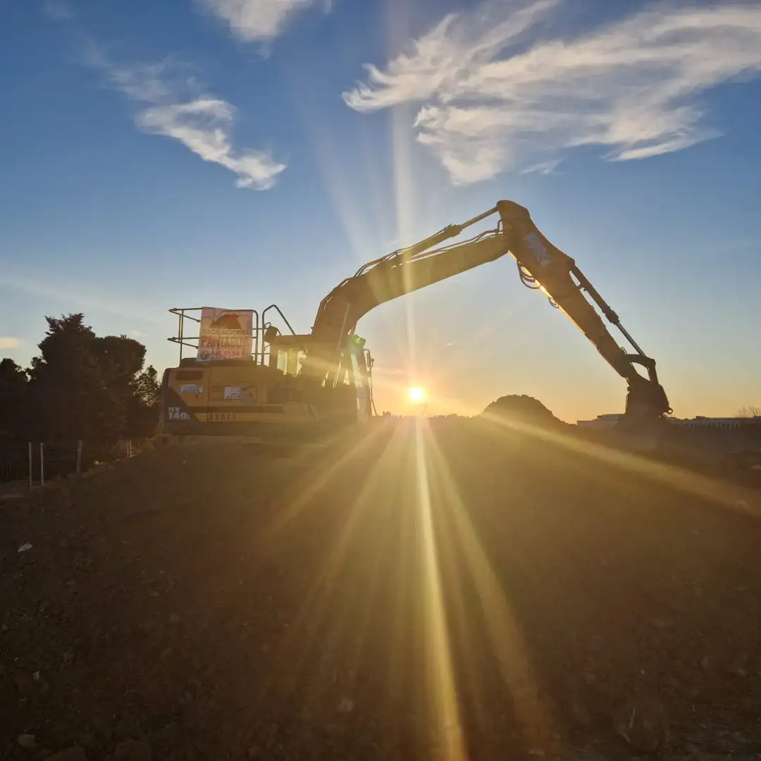 Excavadora de Excavaciones Paniagua trabajando al atardecer en Madrid